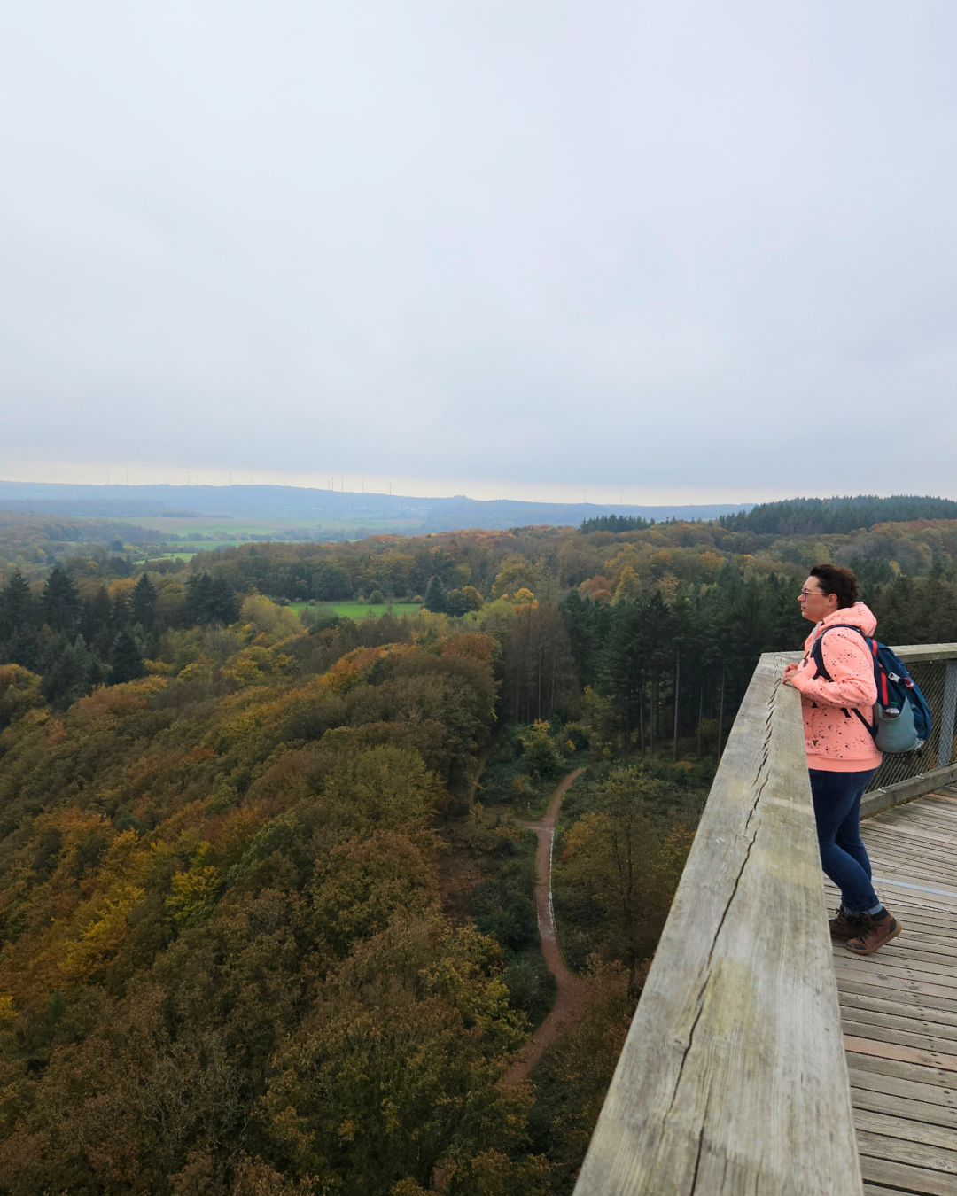 Ingrid tijdens een wandeling met uitzicht over een herfstbos